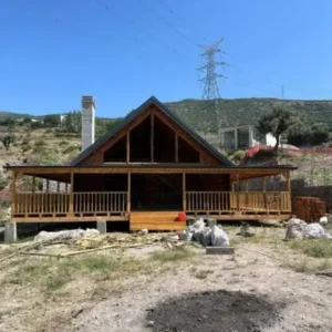 Uzak çekim arkası dağ olan beşik çatı önü verandalı 150 m2 Ağaç tomruk ev
