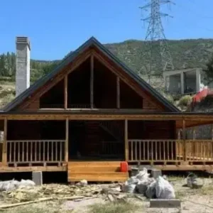 Uzak çekim arkası dağ olan beşik çatı önü verandalı 150 m2 Ağaç tomruk ev