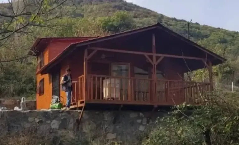 Arkası dağ yeşillikli kırmızı boya atılırken çekilen "müstakil ahşap karkaslı ev"