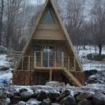 Hafif karlı dağlar eteğinde dik çatı üçgen bungalov ev görseli