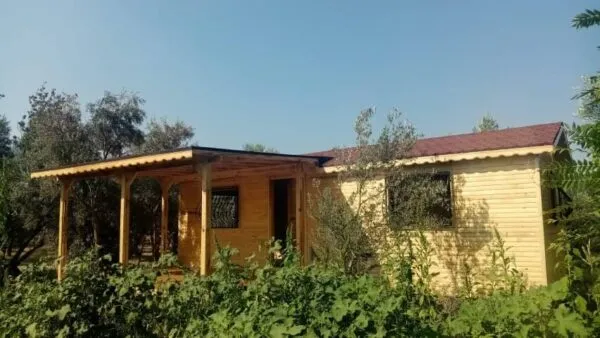 Açık mavi gökyüzü ve yeşillikler arasındaki hazır taşınabilir ahşap bungalov ev